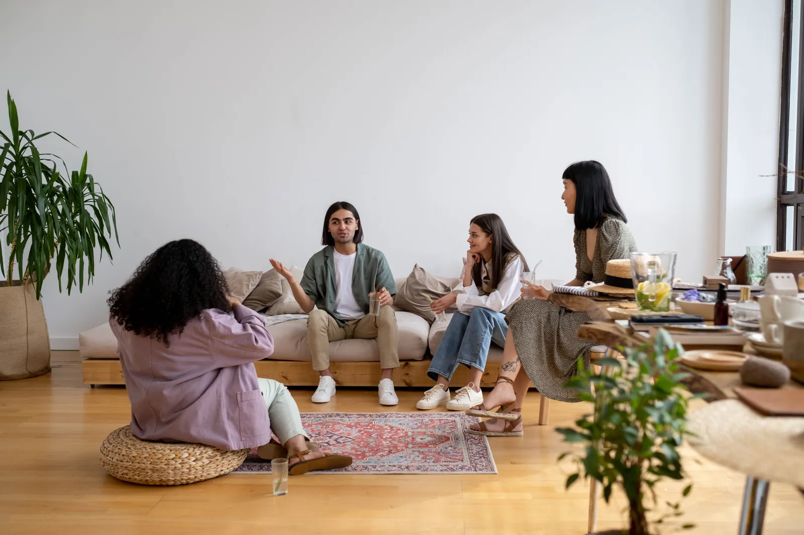 A small group of people sitting together in a living room, talking.